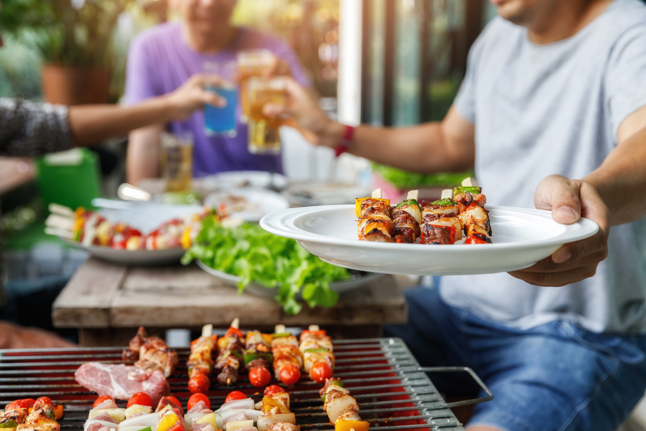 A,Man,With,A,Barbecue,Plate,At,A,Party,Between